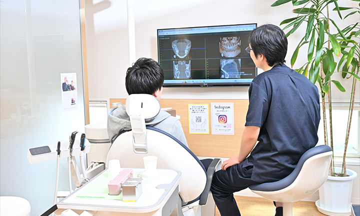 画面を見ながら患者さまに説明する院長